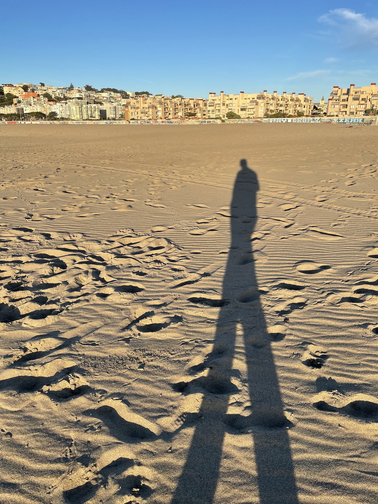 A long shadow on Ocean Beach before or after calling mom to give a trip update.